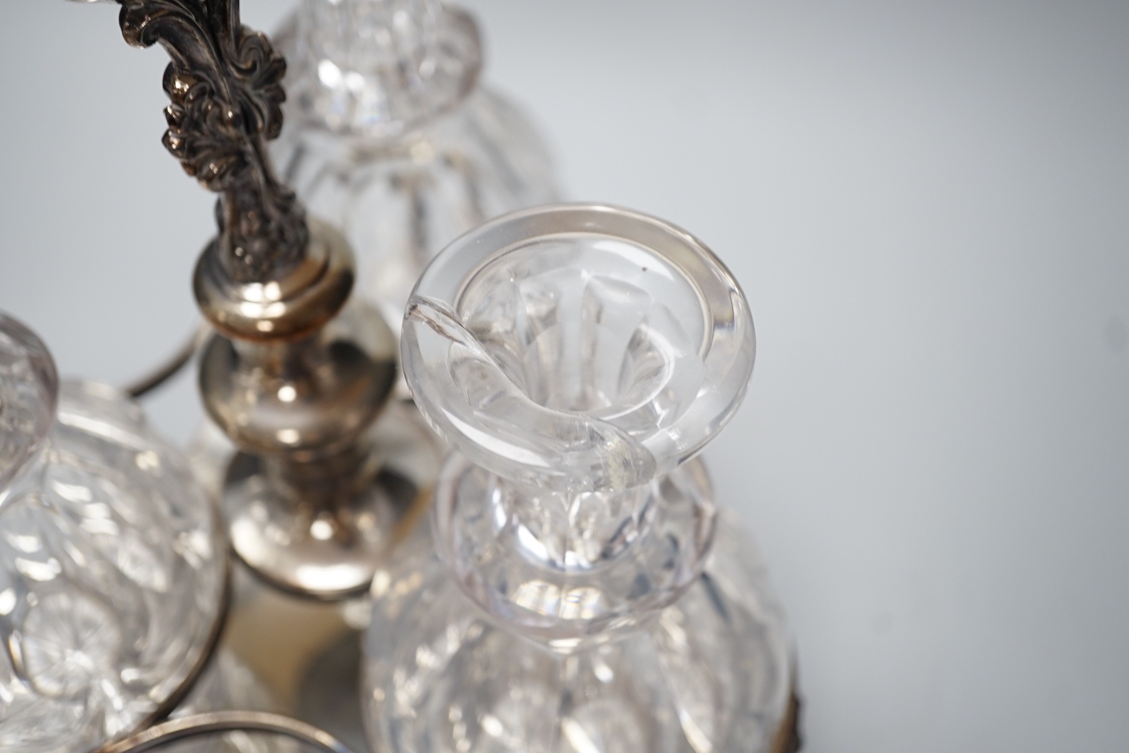 A decorative three bottle decanter set, on lion feet tripod plated stand. 37cm tall